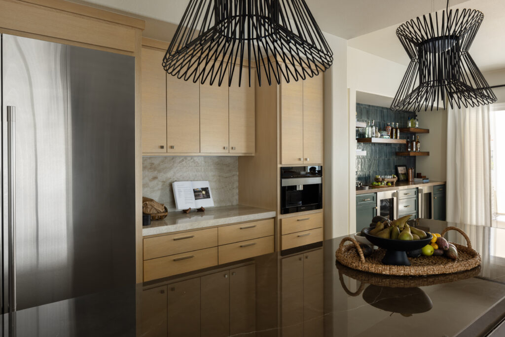 San Clemente Home Renovation with white oak cabinets, miele appliances and quartzite countertops and oversized black pendant lights