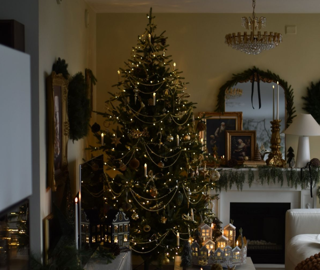 Holiday-decorated living room with a Christmas tree and garland-covered mantel, Orange County home holiday styling.